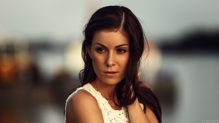 Woman with dark hair in a white top