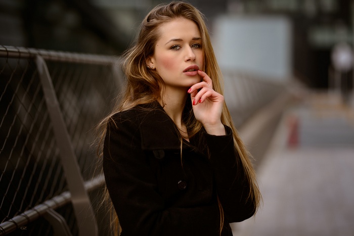 Woman with long blonde hair in a black coat