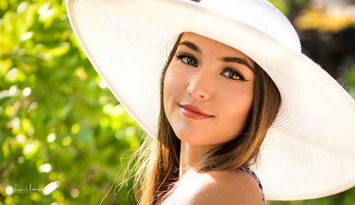 Woman in a white hat with long brown hair