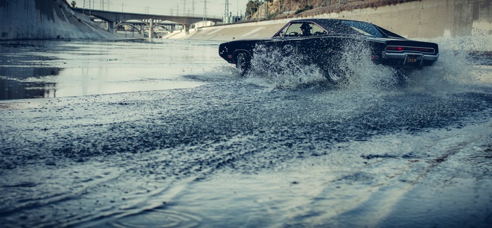 Black Dodge Charger drifting through water
