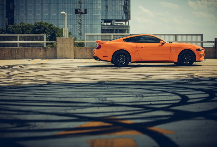 Orange Ford Mustang on a rooftop parking lot