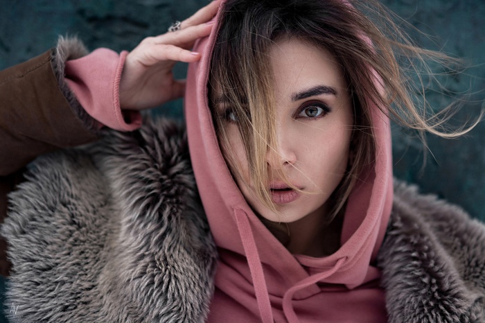 Woman in pink hoodie and fur coat