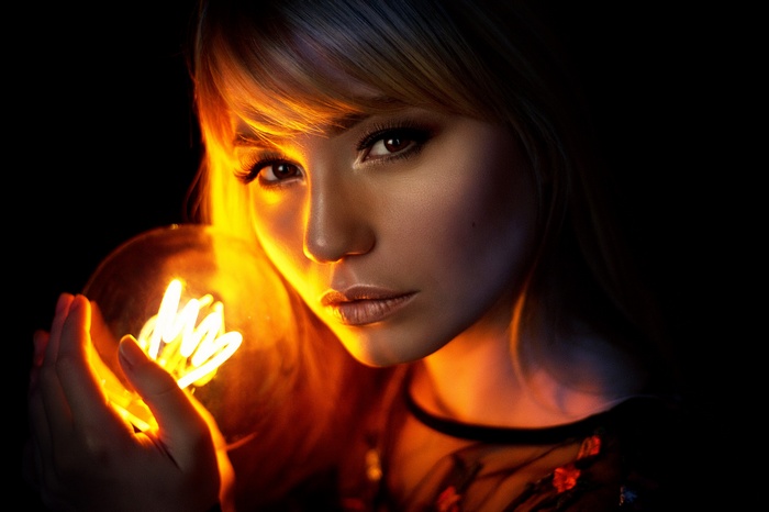 Woman holding a glowing light bulb