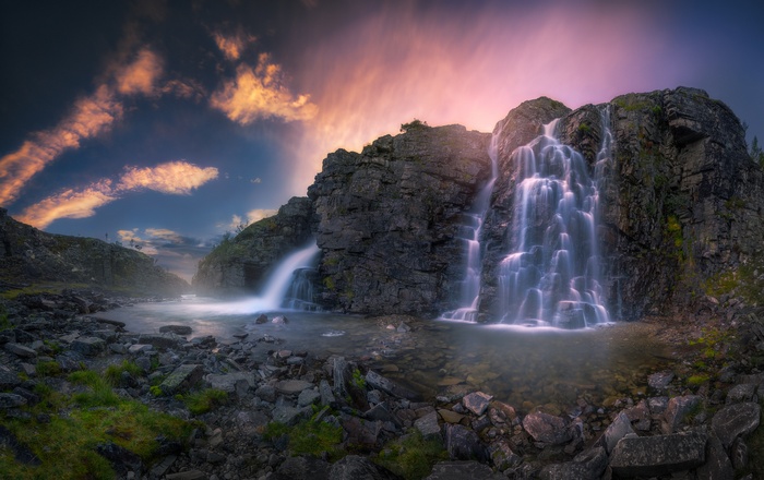 Long exposure waterfall in rocky landscape at sunset