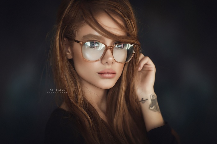 Portrait of a woman with glasses and a tattoo