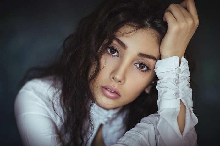 Woman with dark curly hair and brown eyes