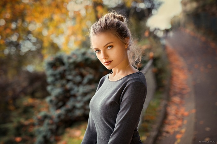 Woman with blonde hair in a grey dress outdoors