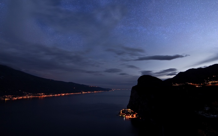 Night landscape with stars over a lake and hills