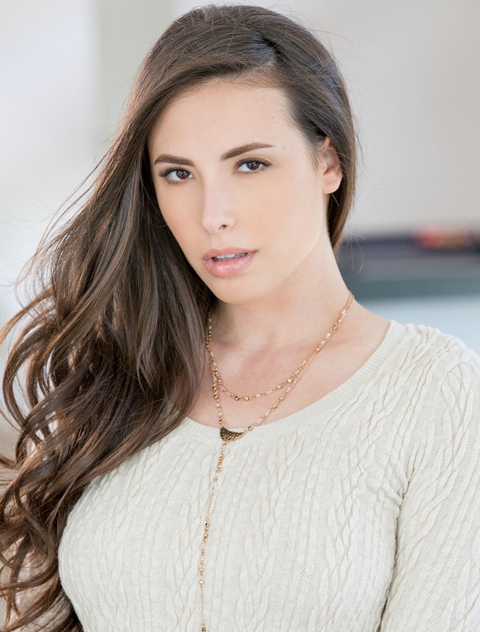 Casey Calvert wearing a white sweater with necklaces