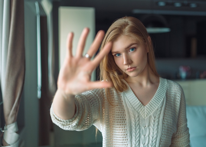 Woman with blonde hair and blue eyes wearing a white sweater