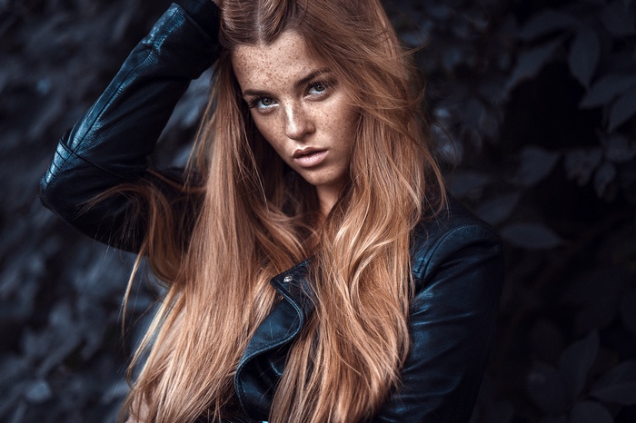 Woman with freckles wearing a leather jacket