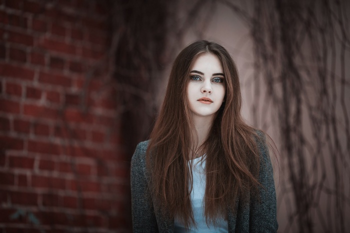 Portrait of a young woman with long brown hair and blue eyes