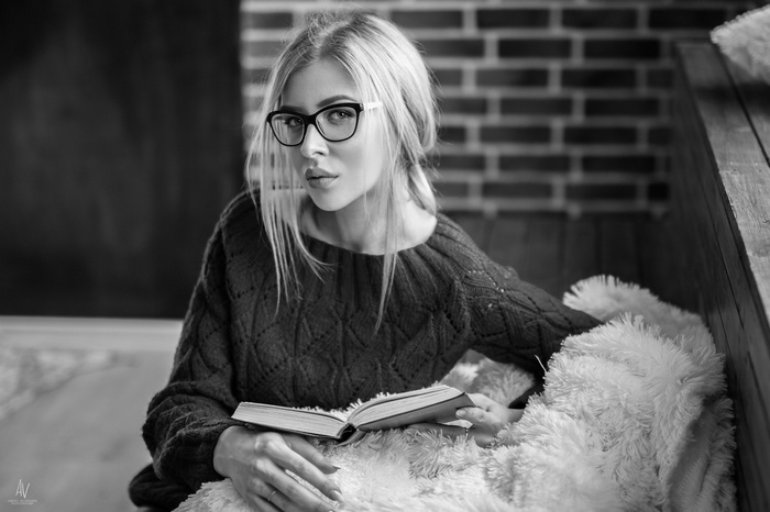 Woman with glasses reading a book