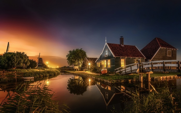 Dutch village with windmills and canal at sunset
