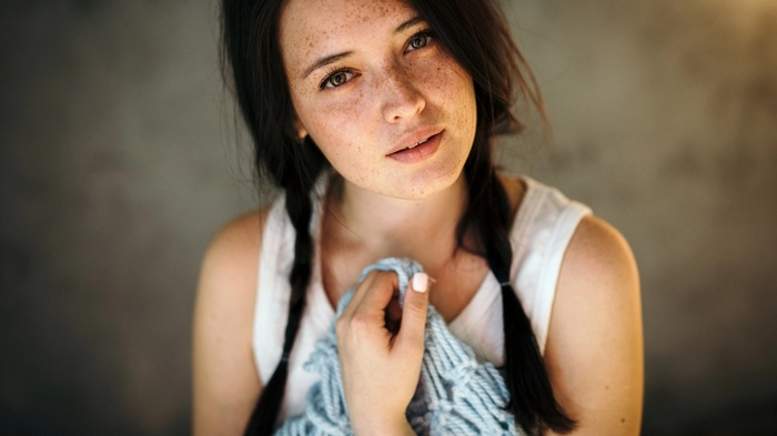 Woman with freckles and pigtails holding a blue scarf