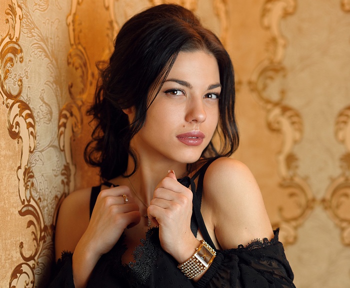 Woman with dark hair and jewelry