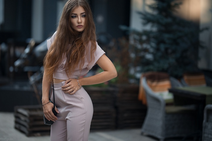Woman with long hair wearing a pink outfit outdoors