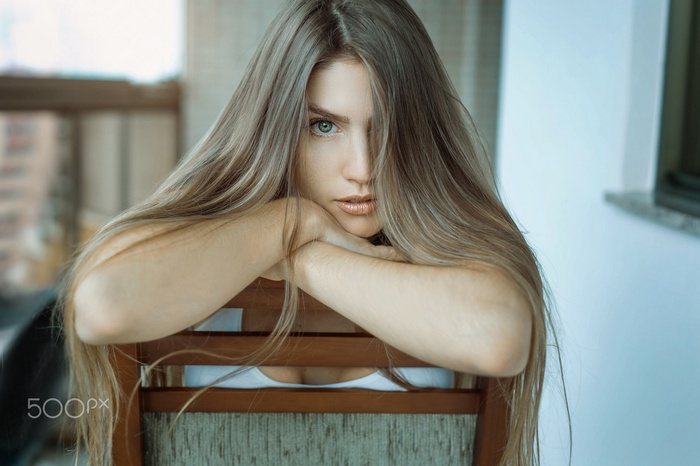 Woman with long blonde hair sitting on a chair