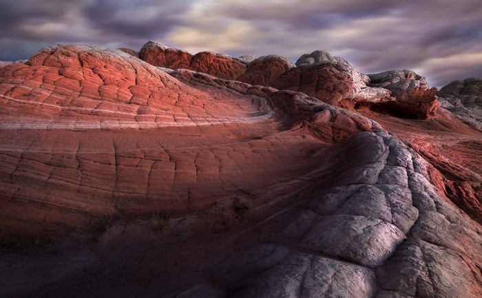 Red and white sandstone formations under a cloudy sky