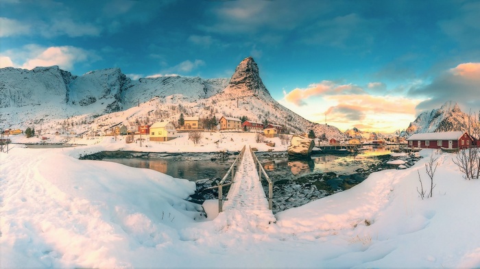 Snowy village with mountains and a bridge in Norway