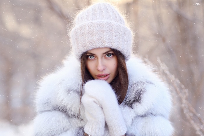 Woman in fur coat and knit hat in snow