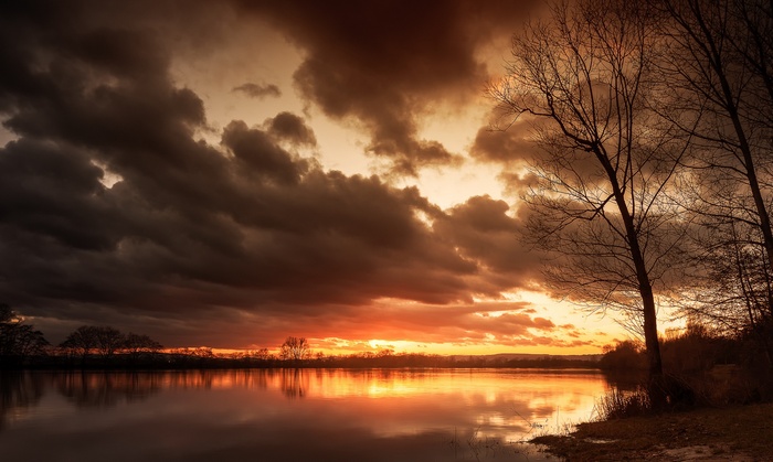 Dark clouds over a lake at sunset