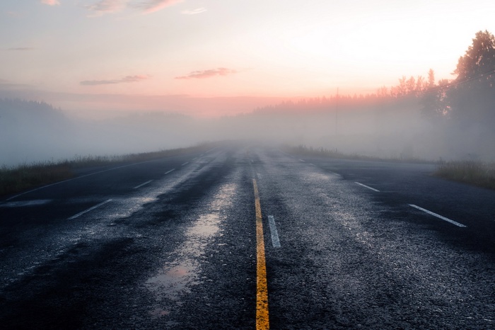 Road through mist at sunrise
