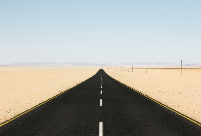 Desert road with telephone poles and mountains
