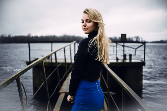 Woman in black turtleneck and blue skirt on a pier