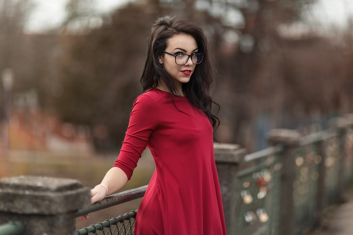 Woman in red dress wearing glasses outdoors