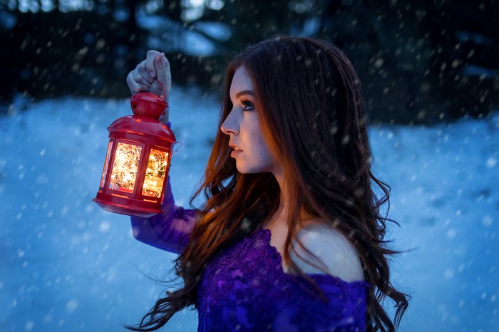 Woman holding a red lantern in the snow