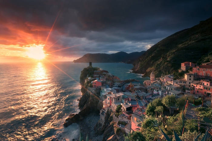Vernazza, Italy at sunset with sun rays over the sea