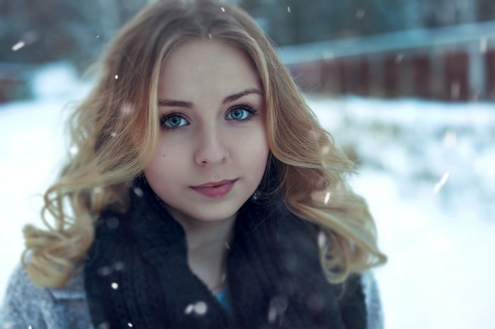 Woman with blonde hair and blue eyes in the snow