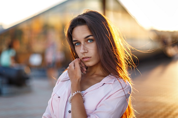 Woman with blue eyes in a pink shirt outdoors