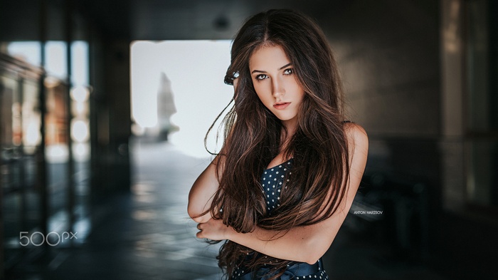 Woman with long brown hair in a polka dot dress