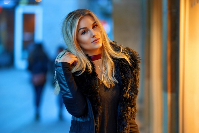 Woman with blonde hair wearing a black coat