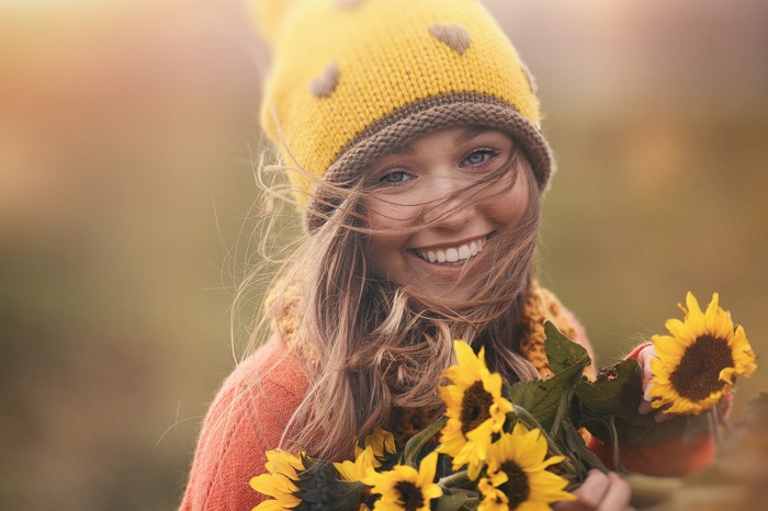 Woman in yellow hat holding sunflowers