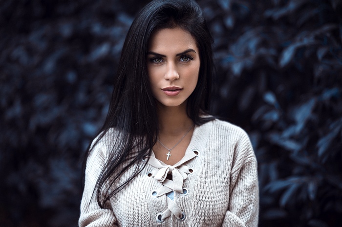 Woman with black hair wearing a necklace