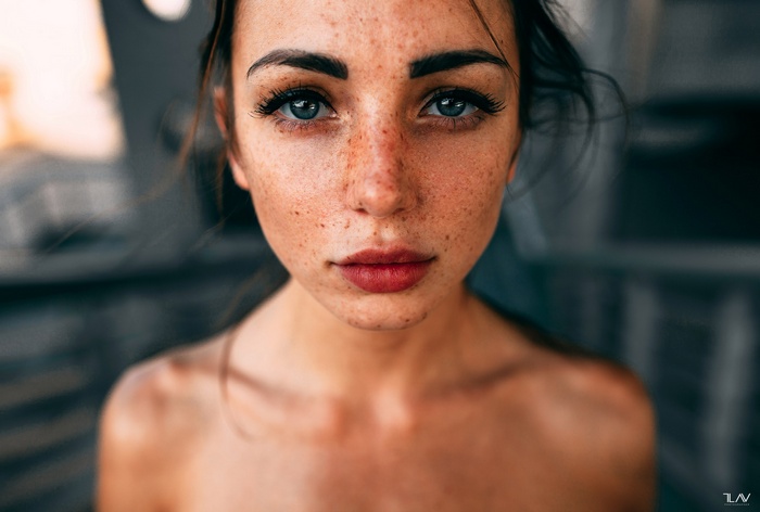 Woman with freckles and blue eyes wearing red lipstick