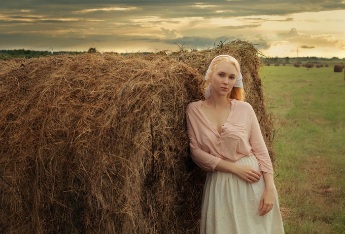 Woman in a field with hay bales