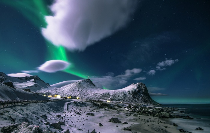 Aurora Borealis over snow-covered mountains and coast