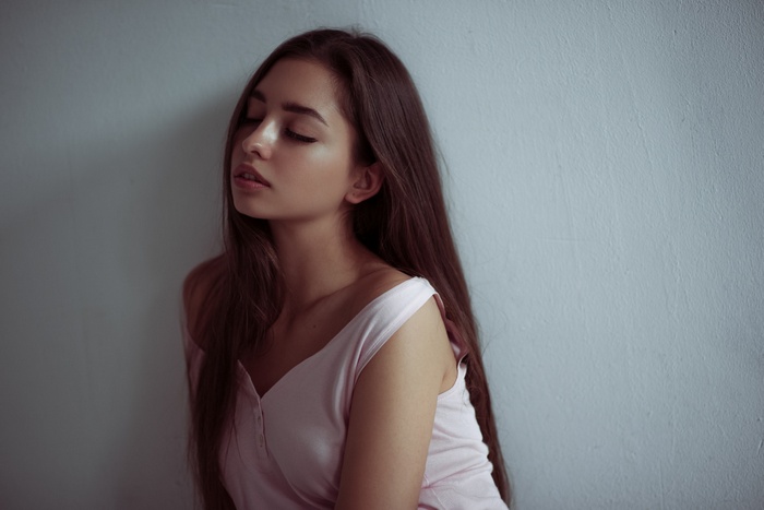 Woman with long brown hair and closed eyes
