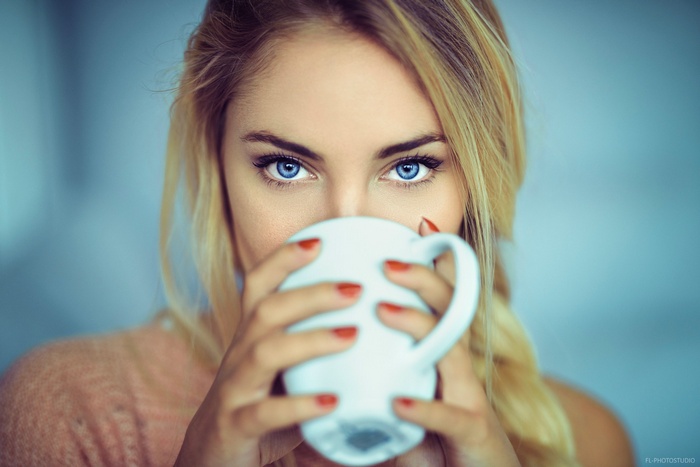 Woman with blue eyes drinking from a cup