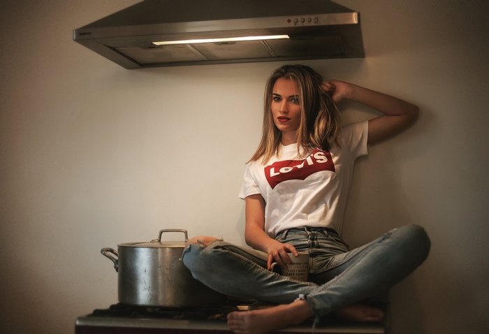 Woman in Levi's shirt sitting in kitchen