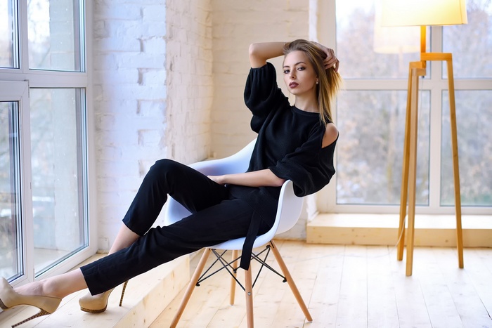 Woman in black clothing sitting in a chair