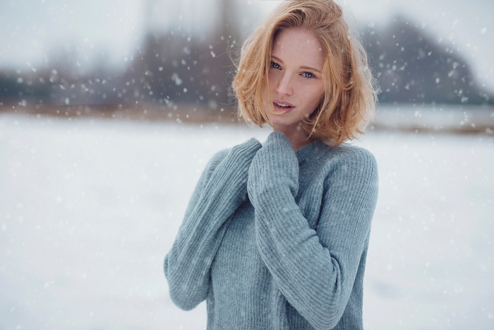 Woman in blue sweater in falling snow