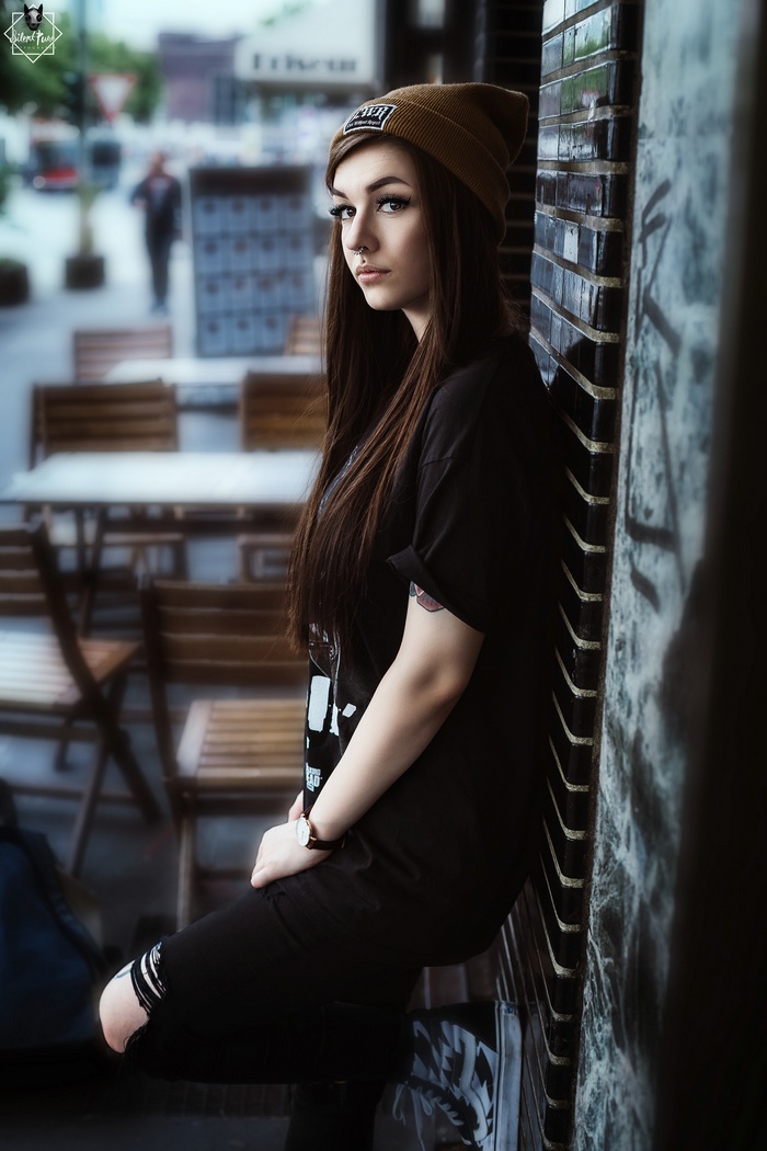 Woman with piercings and tattoos wearing torn jeans