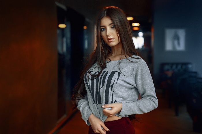 Woman with long brown hair wearing a grey sweatshirt