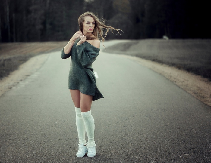 Woman in off-the-shoulder dress and white stockings on a road
