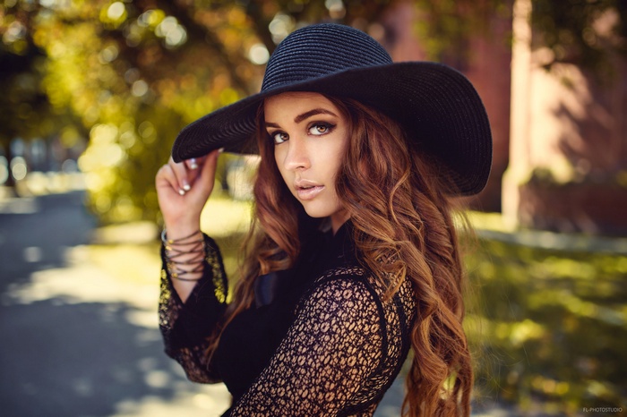 Woman in black hat and lace top outdoors